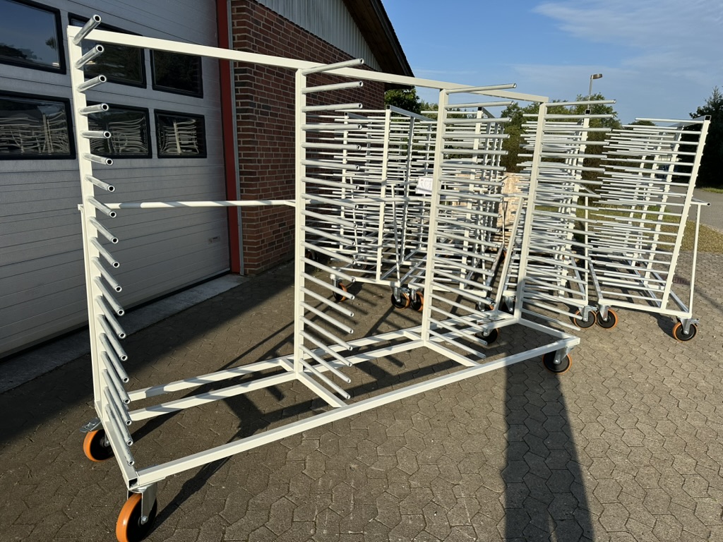 Weiße Produktionswagen mit Rohrgestellen