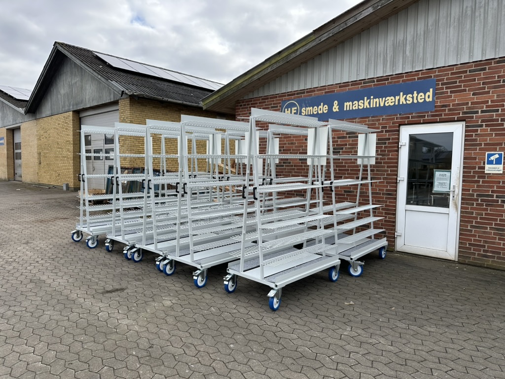Mehrere weiße Transportwagen vor der Werkstatt